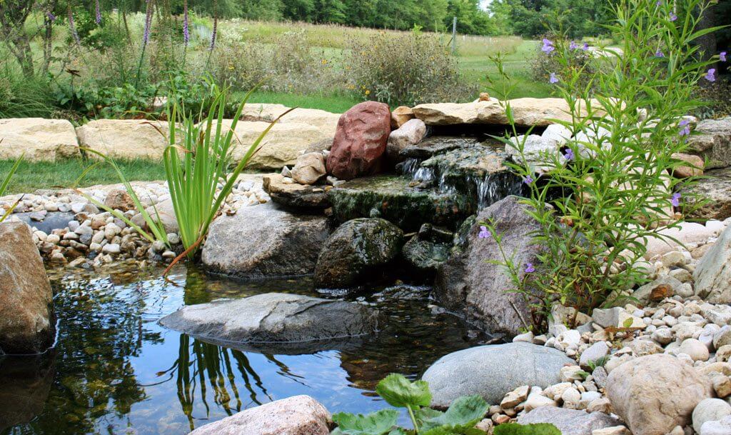 Small man made pond with rocks around it